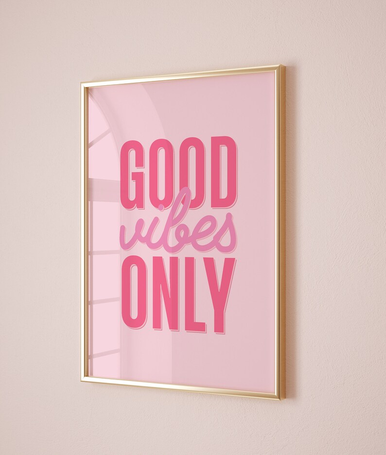 May include: A gold framed pink poster with the text "GOOD vibes ONLY" in pink lettering.