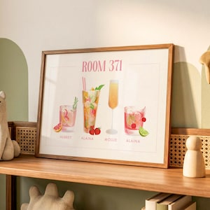 May include: A framed horizontal print titled ROOM 371 featuring four illustrated cocktails. The drinks include a pink beverage with a grapefruit slice, a tall drink with strawberries, a yellow champagne flute, and a red drink with cherries and lime.