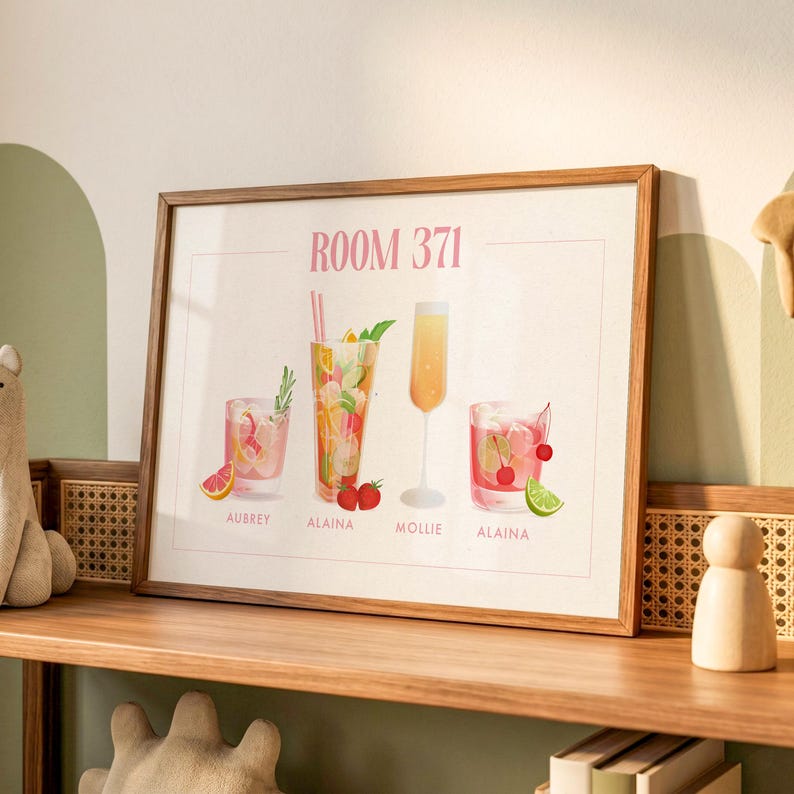 May include: A framed horizontal print titled ROOM 371 featuring four illustrated cocktails. The drinks include a pink beverage with a grapefruit slice, a tall drink with strawberries, a yellow champagne flute, and a red drink with cherries and lime.