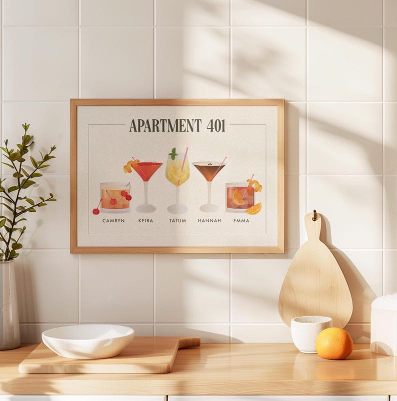 May include: A framed horizontal print titled APARTMENT 401 featuring five illustrated cocktails labeled Camryn, Keira, Tatum, Hannah, and Emma. The artwork displays various glassware including coupes and tumblers with garnishes like cherries and citrus.