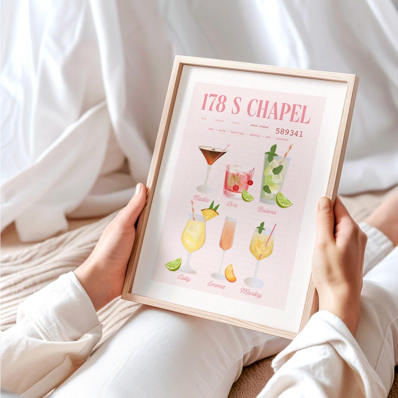 Op de afbeelding: Een ingelijste print met aquarel illustraties van cocktails. De print heeft een lichtroze achtergrond met de tekst "178 S CHAPEL" en "589341" bovenaan. Hieronder staan zes cocktail illustraties met namen als "Nadia" en "Marley".
