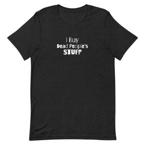 May include: A charcoal gray short-sleeve t-shirt featuring the white text "I Buy Dead People's STUFF" printed on the center of the chest. The shirt has a crew neckline and a standard fit, constructed from a heathered fabric with a visible texture.