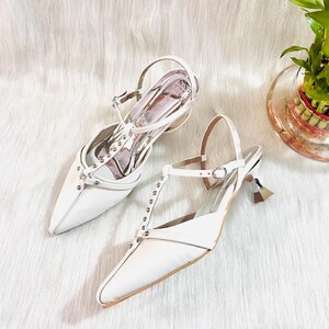 These timeless white pumps exude sophistication with their pointed toe and kitten heel having 2 inch heel.