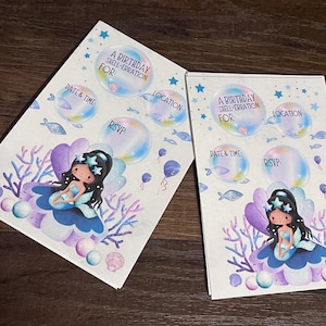 May include: Two mermaid-themed birthday party invitations. Each card features a cartoon mermaid, bubbles, and text fields for date, time, location, and RSVP details. The invitations are decorated with pastel colours and aquatic elements.