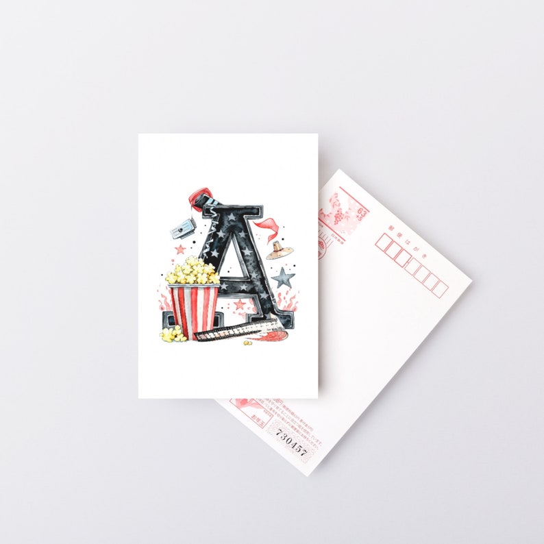 May include: A watercolor illustration of the letter A decorated with movie-themed elements, including popcorn, a film reel, a director's chair, and stars. The letter is black with red and white stripes, and the background is white.