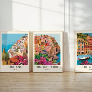 May include: Three framed prints of colourful Italian towns with the names Positano, Cinque Terre, and Portofino written below each image.