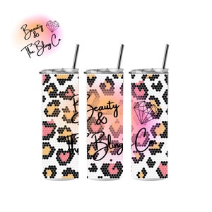May include: Three stainless steel tumblers with a leopard print design and a pink and orange ombre effect. The tumblers have a straw and the text "Beauty & The Bling Co." is printed on the middle tumbler.