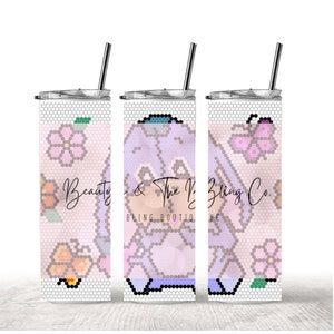 Pode incluir: Três copos de aço inoxidável com um design floral rosa e roxo com um personagem de desenho animado. Os copos têm uma tampa transparente e um canudo. O texto "Beauty & The Bling Co. Bling Boutique" está impresso nos copos.