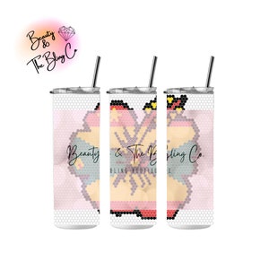 May include: Three stainless steel tumblers with a pink, yellow, and blue floral design. The tumblers have a clear lid and a straw. The design includes the text "Beauty & The Bling Co. Bling Boutique".