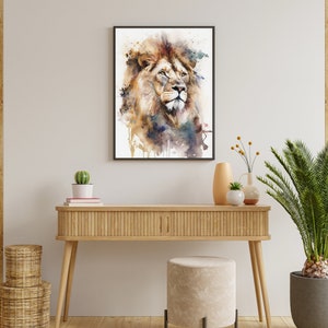 Puede incluir: Una pintura de acuarela de la cabeza de un le&oacute;n con una melena marr&oacute;n, naranja y amarilla. El le&oacute;n mira hacia la derecha y tiene una expresi&oacute;n seria. El fondo es de color azul claro con salpicaduras de pintura marr&oacute;n y amarilla.