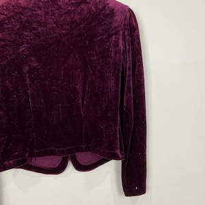 以下が含まれることがあります： 長袖でVネックの濃いパープルのベルベットのブレザー。ブレザーは丈が短く、やや体にフィットしたシルエットです。