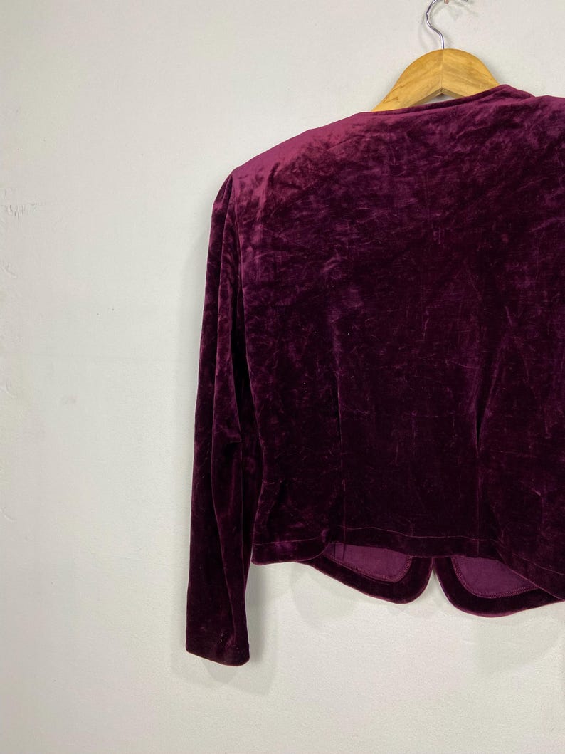 以下が含まれることがあります： 深みのあるボルドーカラーのベルベット素材のロングスリーブクロップドジャケット。クラシックなテーラードフィットで、Vネックラインが特徴です。