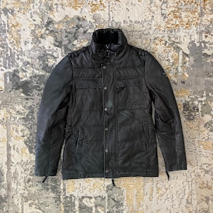 May include: Black leather jacket with a high collar, multiple pockets, and button and zipper closures. The jacket has a quilted design and shoulder accents. A stylish outerwear piece.
