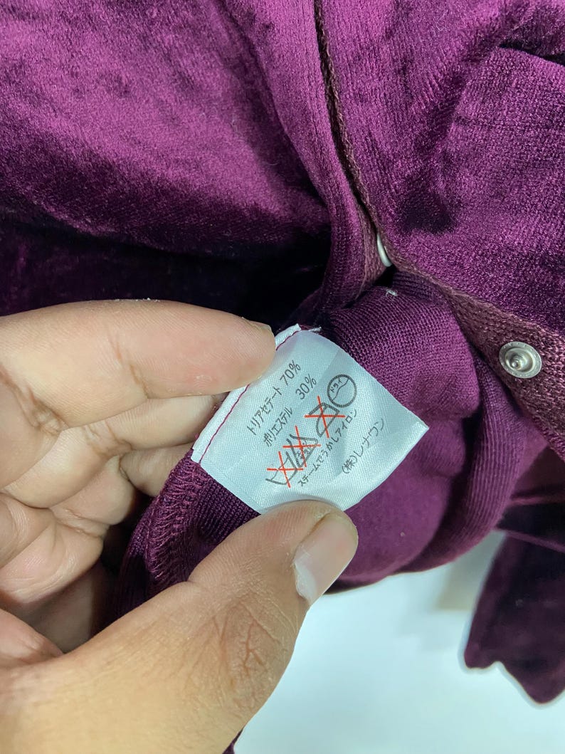 以下が含まれることがあります： リヨセル 70% ポリエステル 30% とメーカー品番 8672 (株)レリアン の文字が書かれた、紫色のベルベット生地のタグのアップ画像です。