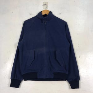 May include: A navy blue bomber jacket with a zipper closure and two pockets. The jacket has a ribbed collar and cuffs.