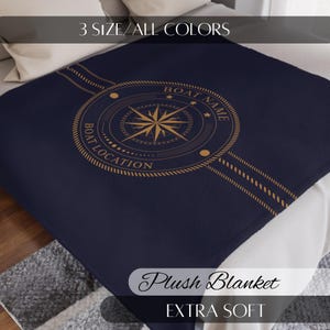 Può includere: Coperta in peluche blu navy con un design a bussola dorata. La coperta presenta il testo "BOAT NAME" e "BOAT LOCATION" attorno alla bussola. È presente anche il testo "3 SIZE/ALL COLORS", "Plush Blanket" e "EXTRA SOFT".