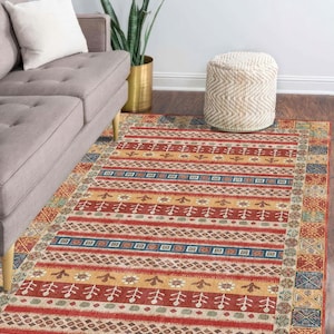 Può includere: Tappeto rettangolare con un motivo geometrico rosso, giallo, blu e beige. Il tappeto presenta un design a righe con motivi ripetuti e un bordo a fantasia. È posizionato su un pavimento in legno scuro.