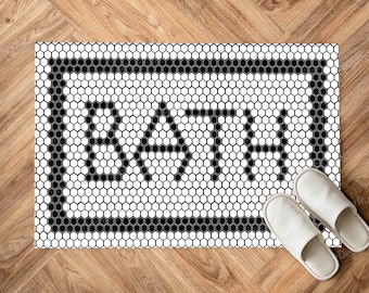 Pode incluir: Tapete de banheiro preto e branco com um padrão de ladrilho hexagonal e a palavra "BATH" em uma moldura preta.