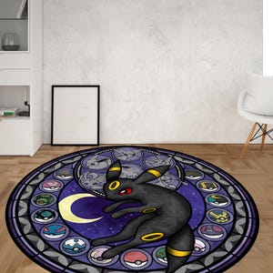 May include: A round, purple and black rug with a stained glass design featuring a black and yellow Pokemon character. The character is surrounded by smaller Pokemon characters in a circle.