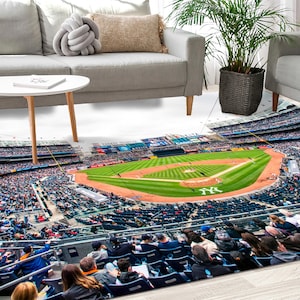 May include: A baseball stadium rug with a green field, white baselines, and a crowd of people in the stands. The rug is laid out on a white floor with a white coffee table and two white couches in the background.