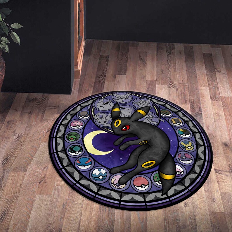 May include: A round rug with a stained glass design featuring a black and yellow Pokemon character, known as Umbreon, sleeping on a crescent moon. The design includes a purple background with a starry sky and a circle of Pokemon symbols around the edge.