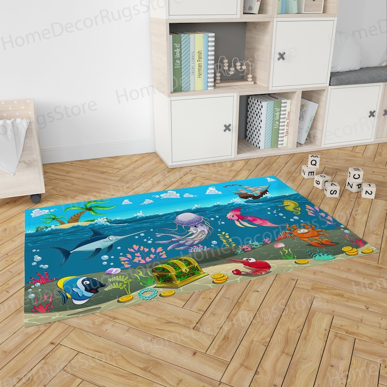 Puede incluir: Una alfombra colorida que representa una escena submarina con un fondo azul, un cofre del tesoro, una medusa, un pez espada, un caballito de mar y un cangrejo. La alfombra es perfecta para la habitaci&oacute;n de un ni&ntilde;o o un &aacute;rea de juegos.