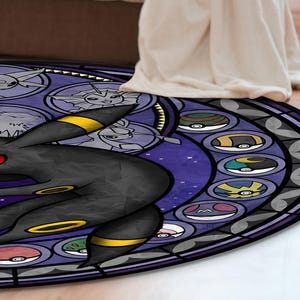 May include: A round, purple and black rug with a stained glass design featuring a black and yellow Pokemon character, surrounded by smaller Pokemon characters in circles.