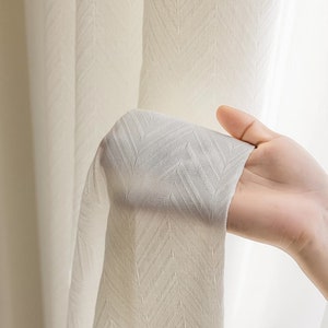 May include: White sheer curtains with a subtle herringbone pattern. The curtains are made of a lightweight fabric and have a soft, drapey feel.