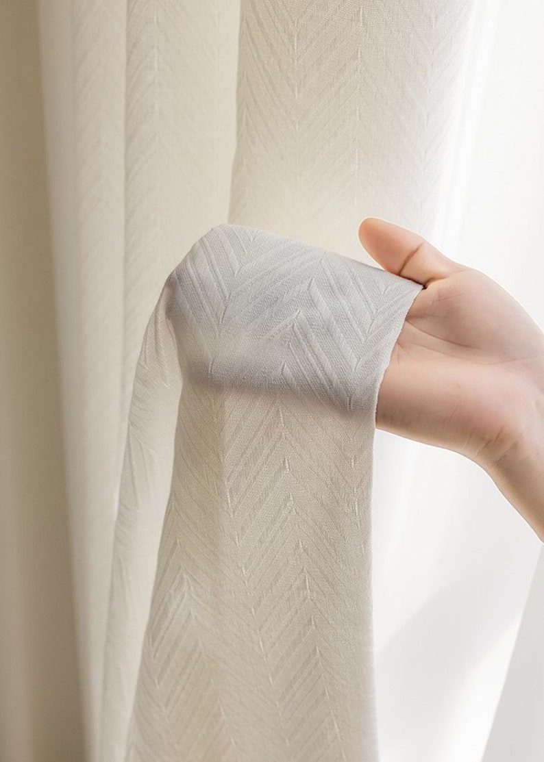 May include: White sheer curtains with a subtle herringbone pattern. The curtains are made of a lightweight fabric and have a soft, drapey feel.