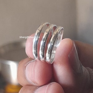 May include: Three silver rings stacked on top of each other. The rings are hammered and have a textured finish.