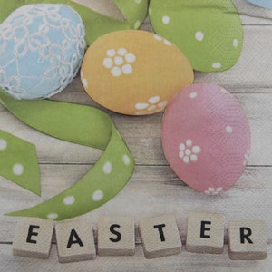 2 oder 4 Stück Papierservietten für Decoupage, Pastellfarben Ostereier, grünes Geschenkband und Inschrift Ostern auf beige Bretter Hintergrund