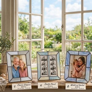 K&ouml;nnte beinhalten: Drei Glasmalerei-Fotorahmen mit Fotos. Die Rahmen sind in Blau-, Wei&szlig;- und Graut&ouml;nen gehalten. Der Text auf den Etiketten lautet "Classic Elegant", "Double Panel" und "Wedding Symbol".