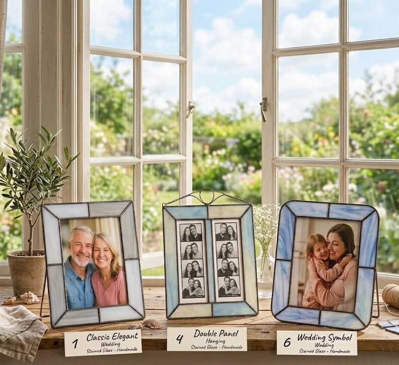 K&ouml;nnte beinhalten: Drei Glasmalerei-Fotorahmen mit Fotos. Die Rahmen sind in Blau-, Wei&szlig;- und Graut&ouml;nen gehalten. Der Text auf den Etiketten lautet "Classic Elegant", "Double Panel" und "Wedding Symbol".