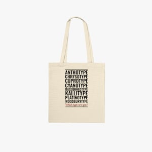 May include: A beige tote bag with black text listing different types of photographic processes, including "Anthotype", "Chrysotype", "Cyanotype", "Daguerreotype", "Kalliotype", "Platinotype", and "Woodburytype". The text ends with the question "Which type are you?"