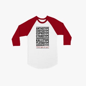 May include: A white and red baseball tee shirt with the text "ANTHOTYPE, CHRYSOYPE, CUPROTYPE, CYANOTYPE, DAGUERREOTYPE, KALLITYPE, PLATINOTYPE, WOODBURYTYPE" and "Which type are you?" printed in black.