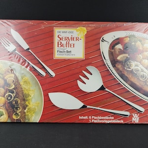 May include: A boxed stainless steel fish serving set. The set includes a fork, knife, serving fork, and serving spoon. The box has the text "SERVIER-Buffet Fisch-Set" and "Inhalt: 6 Fischbestecke 1 Fischvorlegebesteck".