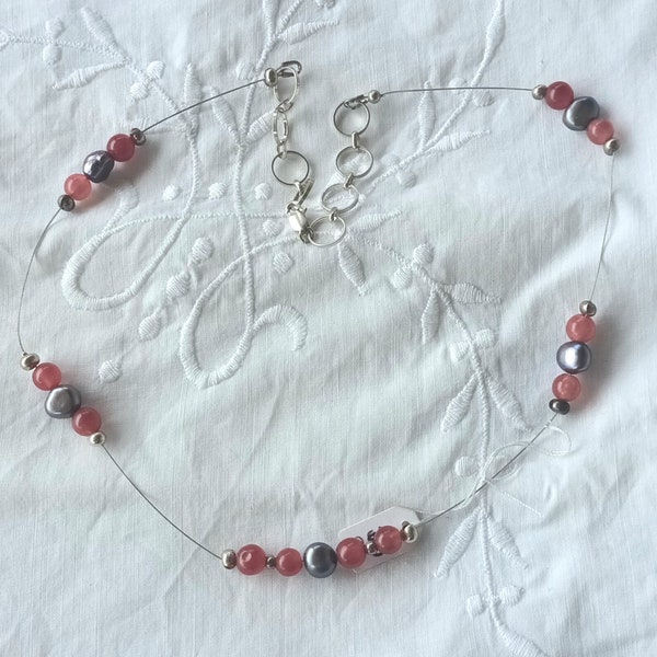 Collier IJADA en fil câblé portant des perles de jade rouge, des perles d'eau douce et des perles argentées. Fermoir en argent 925.