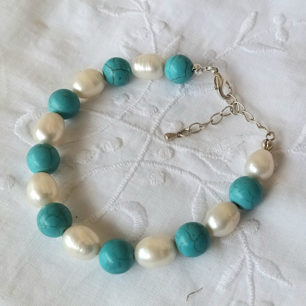 Bracelet PEARL portant des perles en véritable turquoise et des perles d'eau douce. Fermoir argenté mousqueton réglable avec une chaînette.