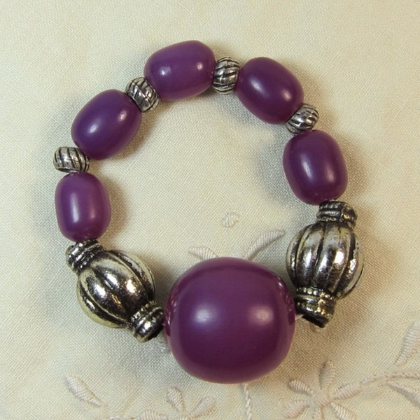 Bracelet élastique CORTINA formé de grosses perles en bois violettes Vintage Années 70 et de perles ciselées en métal argenté vieilli