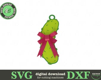 May include: A green pickle ornament with a pink bow. The pickle has a loop at the top for hanging. The image also includes the text "SVG digital download for cutting machines DXF".