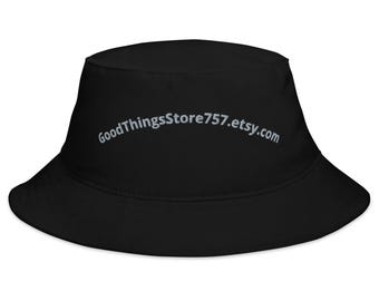 May include: Black bucket hat with a wide brim. The hat features the text "GoodThingsStore757.etsy.com" in a light color across the front. The hat is made of a soft material and is suitable for various outdoor activities.
