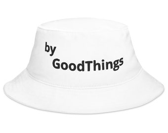 May include: White bucket hat with the text "by GoodThings" in black. The hat is made of a soft material and has a wide brim. A casual accessory for sun protection or fashion.