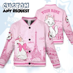 Può includere: Giacca bomber rosa con un gatto dei cartoni animati e un fiocco rosa, ambientata in un paesaggio parigino con la Torre Eiffel. La giacca ha bottoni neri e il testo "CUSTOM ANY REQUEST" sul davanti.
