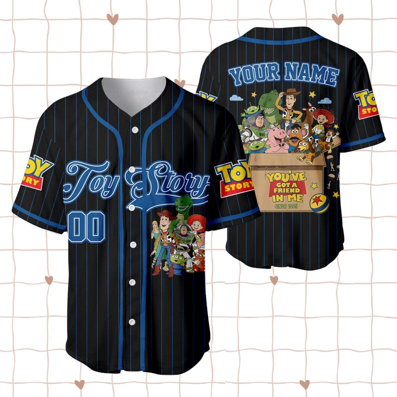 May include: A black baseball jersey with blue pinstripes, featuring Toy Story characters on the front and back. The front displays the Toy Story logo and the number 00. The back shows characters in a box with the text YOU'VE GOT A FRIEND IN ME.