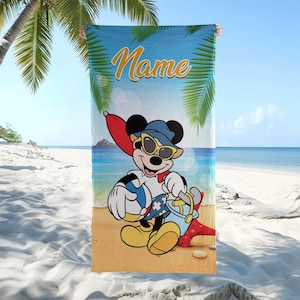 以下が含まれることがあります： ミッキーマウスが描かれたビーチタオル。ミッキーはサングラス、帽子、水着姿で、ビーチボールとバケツを持っています。タオルは青い空を背景にヤシの木があり、黄色で「Name」と書かれています。