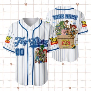 May include: A white baseball jersey with blue pinstripes, featuring Toy Story characters on the front and back. The front displays the Toy Story logo and the number 00. The back shows characters in a box with the text You've Got A Friend In Me.