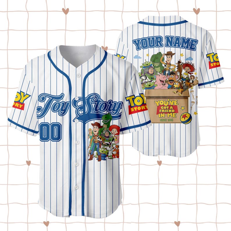 May include: A white baseball jersey with blue pinstripes, featuring Toy Story characters on the front and back. The front displays the Toy Story logo and the number 00. The back shows characters in a box with the text You've Got A Friend In Me.