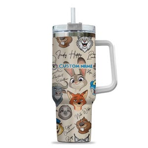 Puede incluir: Un vaso beige con caras de personajes de dibujos animados de Zootopia, incluyendo a Judy Hopps y Nick Wilde. El vaso tiene un asa blanca, una tapa plateada y una pajita. El texto "CUSTOM NAME" tambi&eacute;n es visible.