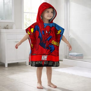 May include: Red hooded beach towel featuring a Spider-Man graphic. The towel has a red and black cityscape design at the bottom, with the word "NAME" printed on a red banner. The hood is red with a dotted pattern.