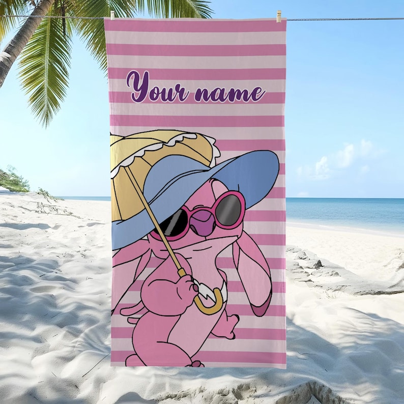 May include: Pink beach towel with horizontal pink and white stripes. Features a cartoon character wearing sunglasses, a blue hat, and holding a yellow umbrella. The text "Your name" is written in purple.